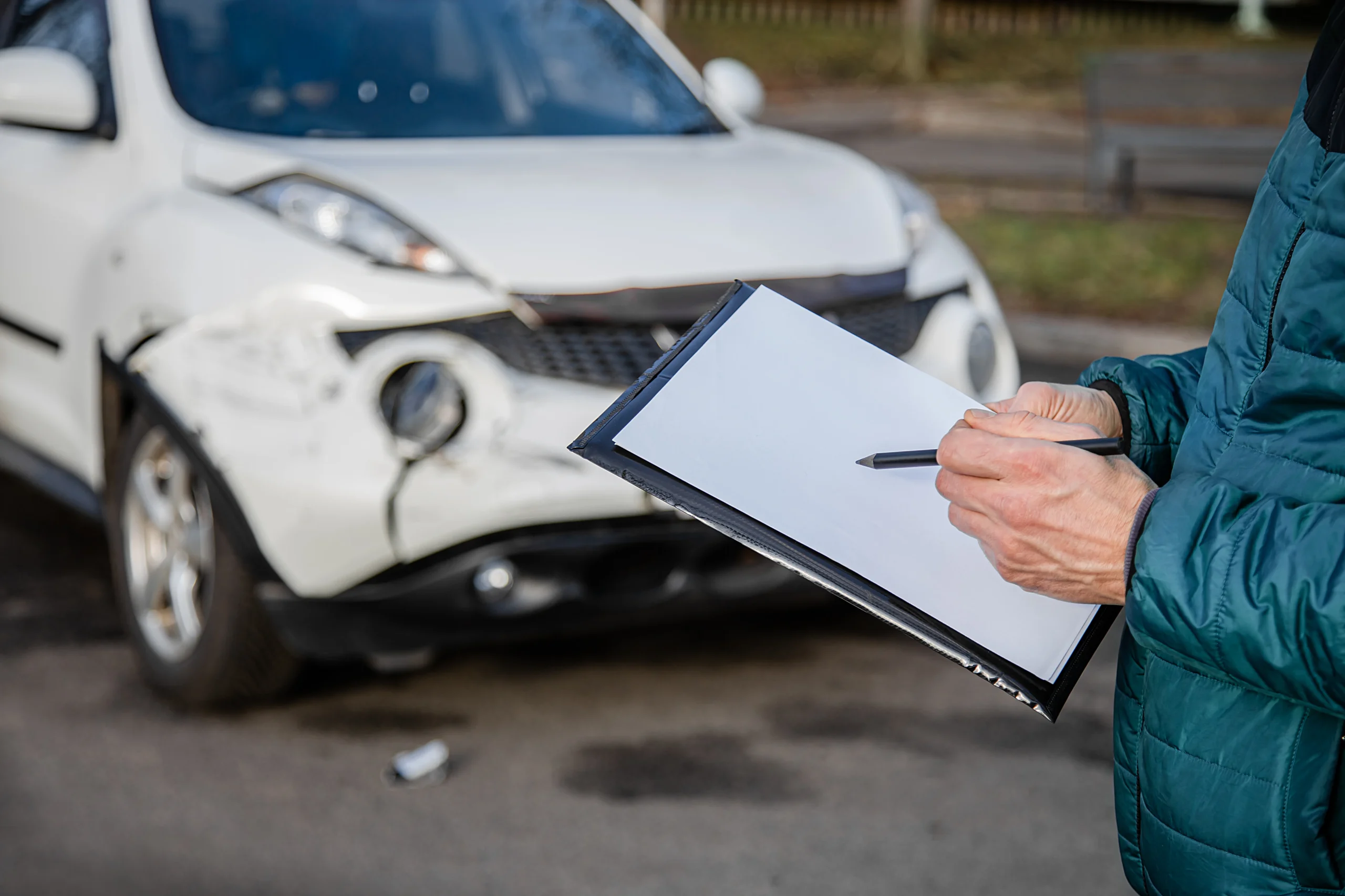 135663980_l Insurance agent will examine and examine the damage to the car after an accident.